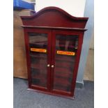 A mahogany double door wall cabinet bearing Matchbox advertising