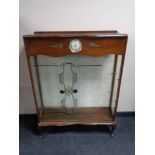 A mid 20th century walnut display cabinet fitted with a Smith's clock