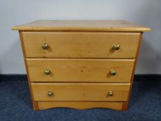 A pine three drawer chest with glass handles