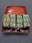 An antique tin trunk containing four jerry cans