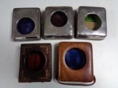 A box containing three silver pocket watch desk stands and two leather examples