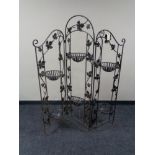 A folding wrought iron plant stand