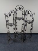 A folding wrought iron plant stand