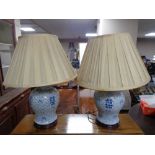 A pair of Chinese blue and white table lamps on wooden bases with shades