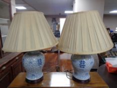 A pair of Chinese blue and white table lamps on wooden bases with shades