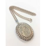 An engraved silver locket on chain