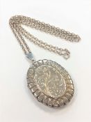 An engraved silver locket on chain