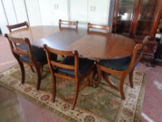 A mahogany brass inlaid twin pedestal dining table with leaf together with six chairs