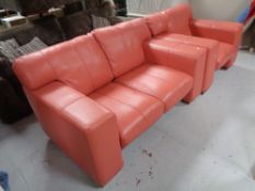 A two seater settee and armchair in salmon pink leather