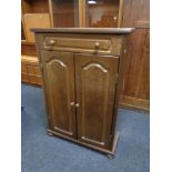 An oak double door cabinet on bun feet