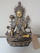 A patinated bronze deity figure in lotus position, with jewelled cabochon decoration,