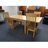 A contemporary oak turnover top dining table and four high back chairs