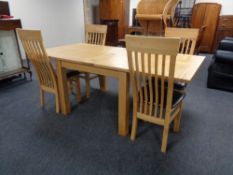 A contemporary oak turnover top dining table and four high back chairs