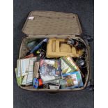 A luggage case containing fishing equipment to include magazines and DVD's, reels,