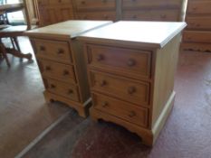 A pair of pine three drawer bedside chests