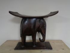 A carved hardwood African seat on elephant base