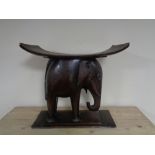 A carved hardwood African seat on elephant base