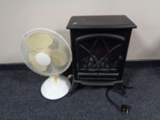 An electric heater in the form of a stove together with an oscillating table fan