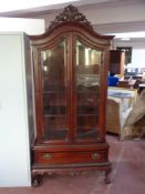 A Victorian style double door display cabinet fitted with drawer beneath