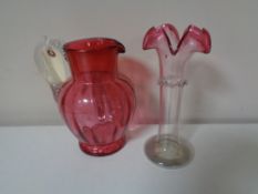 A Victorian cranberry glass water jug together with an antique two-tone glass crimped vase