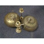 A pair of brass Moroccan style light shades together with a pair of Eastern brass candlesticks