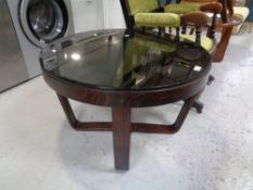 A circular stained beech coffee table with a smoked glass top