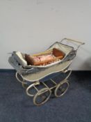 A mid century Coach built doll's pram together with a dolls cot and two dolls