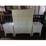 A contemporary white six drawer chest together with a pair of matching two drawer bedside stands