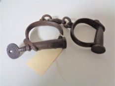 A pair of Hiatt No 12 handcuffs, late 19th century with original 'Screw' key.