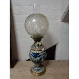 An antique glazed pottery and brass oil lamp with chimney and shade CONDITION REPORT: