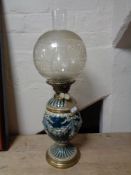 An antique glazed pottery and brass oil lamp with chimney and shade CONDITION REPORT: