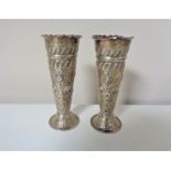 A pair of London silver embossed vases, height 11 cm.