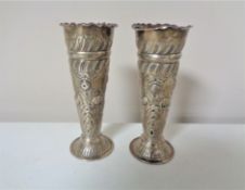 A pair of London silver embossed vases, height 11 cm.