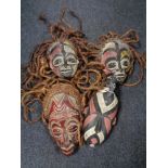 Four African tribal carved and painted masks, three with rope hair, probably Congo.
