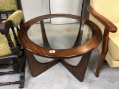 A circular mid 20th century teak glass topped coffee table