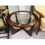 A circular mid 20th century teak glass topped coffee table