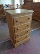 A narrow pine four drawer chest