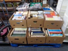 A pallet of nine boxes of hardback and paperback books, novels, history,