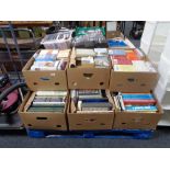 A pallet of nine boxes of hardback and paperback books, novels, history,