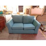 A two seater settee in turquoise fabric