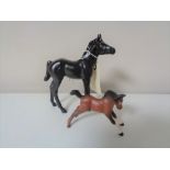Two Beswick foals, one in black and one in brown.