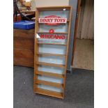 A glazed door wall cabinet bearing Dinky Toy advertising