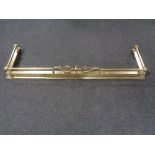 An antique brass extending fire curb