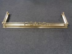 An antique brass extending fire curb