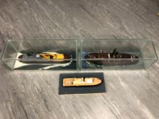 Three model ships, two under glass domes, longest 61cm.