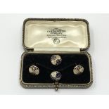 A set of 4 gold white and black enamel studs, 4.25g.