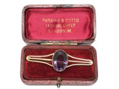 An antique gold brooch set with a large amethyst