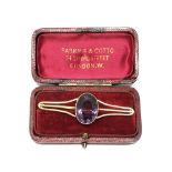 An antique gold brooch set with a large amethyst