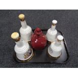A tray of four Bells Scotch whisky decanters (one with contents unsealed) and one further decanter