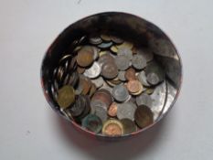 A tin of pre decimal British and foreign coins.